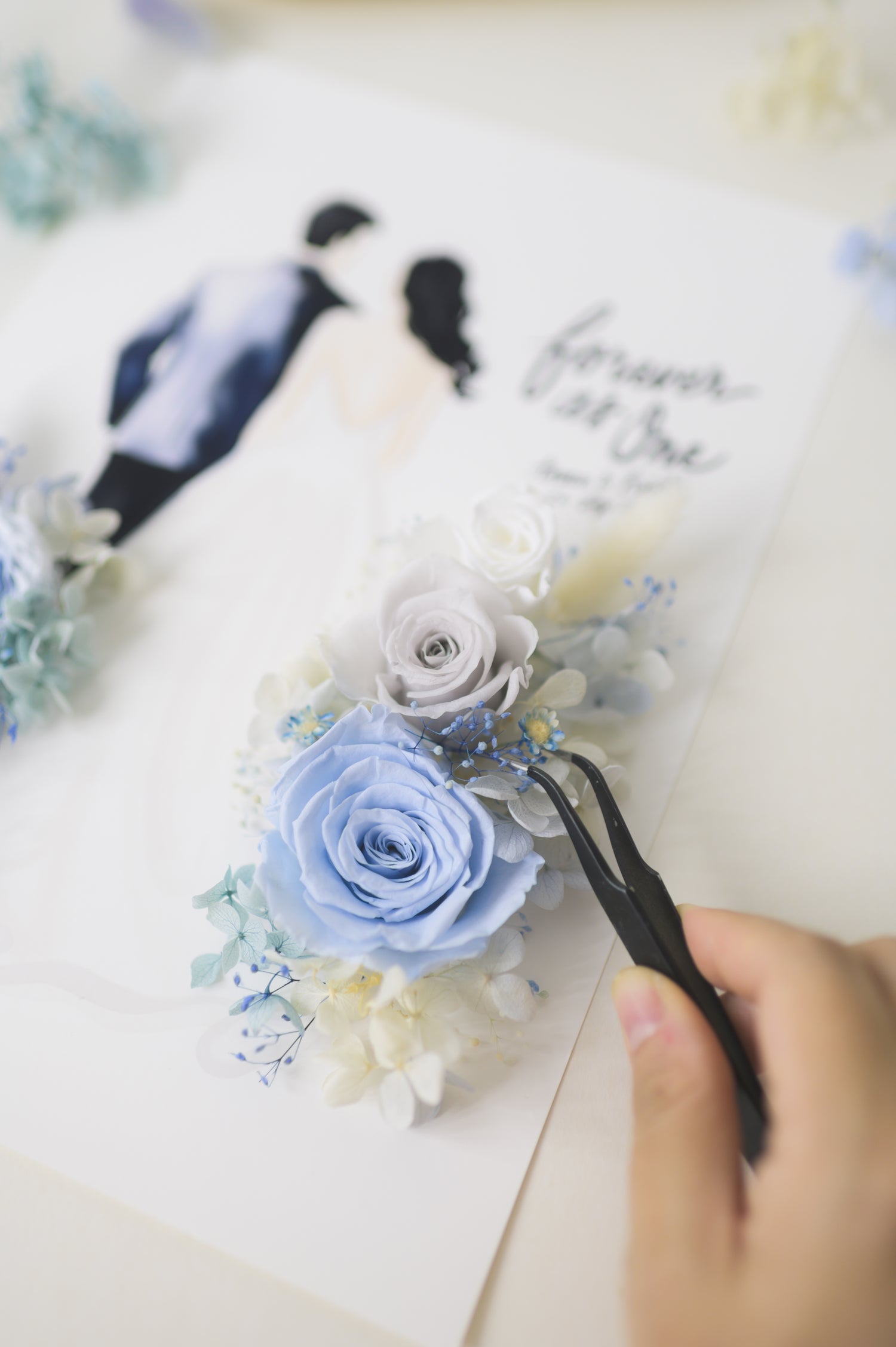 Forever as One wedding frame featuring a custom bride and groom illustration with blue preserved flowers, personalized with names and date, being handcrafted by Limzy.